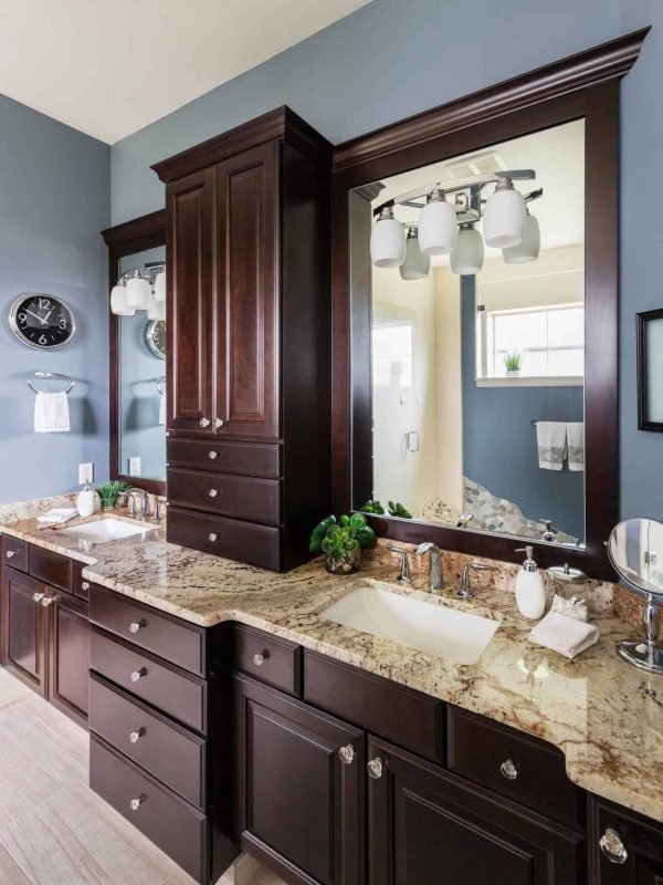 Modern bathroom with dark wood cabinets and granite countertop.