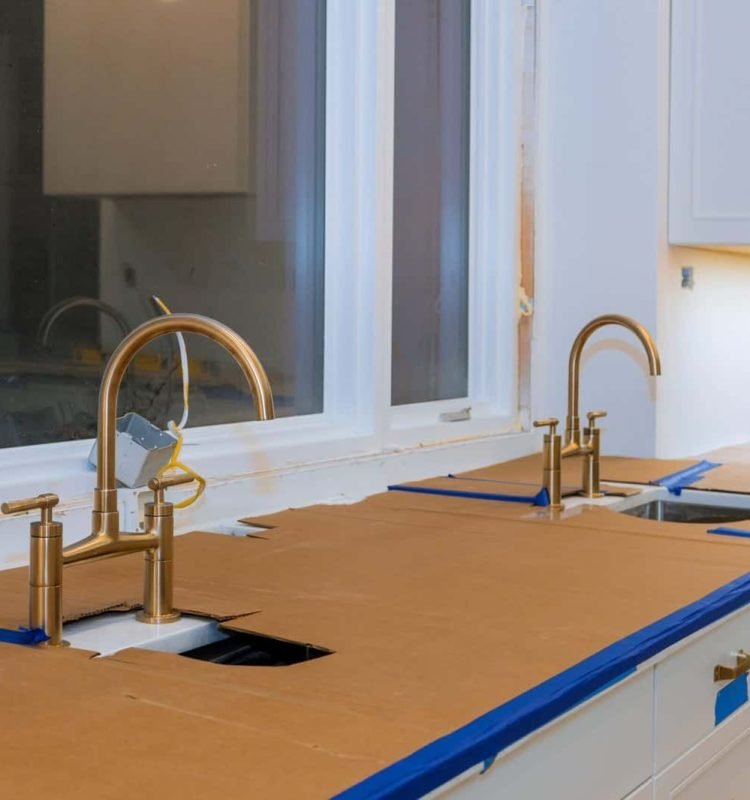Modern kitchen with new cabinetry and gold fixtures by Olague Construction Inc.