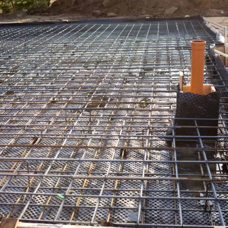 Steel rebar grid for concrete foundation at construction site.