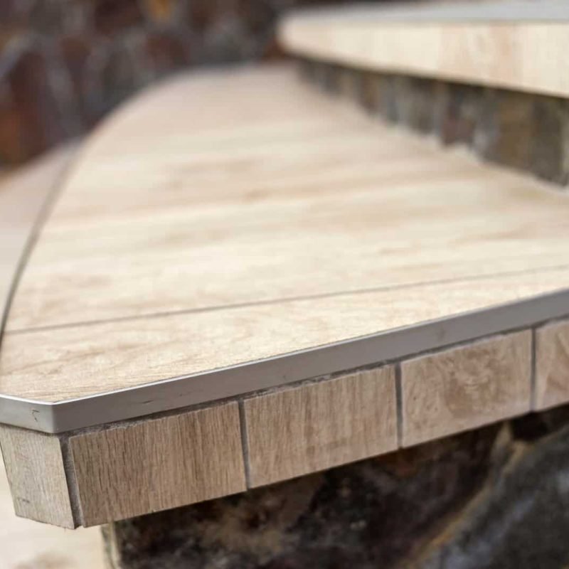 Close-up of a custom wooden bench with metal edging for outdoor seating.