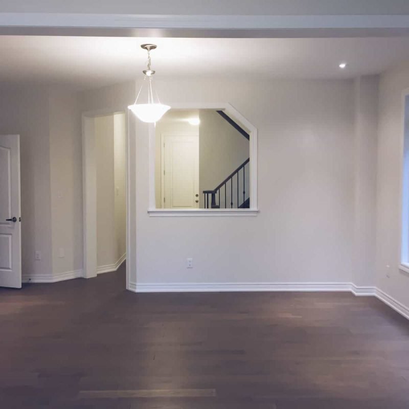 Spacious living room with large windows and modern lighting.